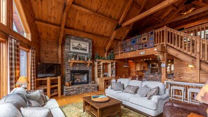 A spacious log cabin interior with a fireplace, a television, and a cozy seating area. - Beary Relaxing Cabin - Big views, two kitchens, hot tub, game table (Banner Elk)