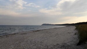 A beach with a sandy shore and a distant landmass.