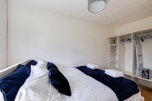 A bedroom with a bed, a wardrobe, and a ceiling light. - Lovely 2 Bedroom Apartment With Fireplace (Manchester)