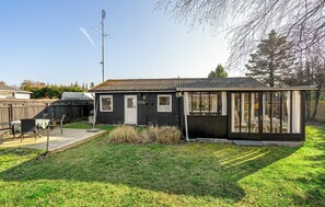 A small, single-story house with a black exterior and a glass conservatory. - 2 bedroom amazing home in Væggerløse (Væggerløse)