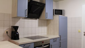Una cocina equipada con microondas, estufa y cafetera.
