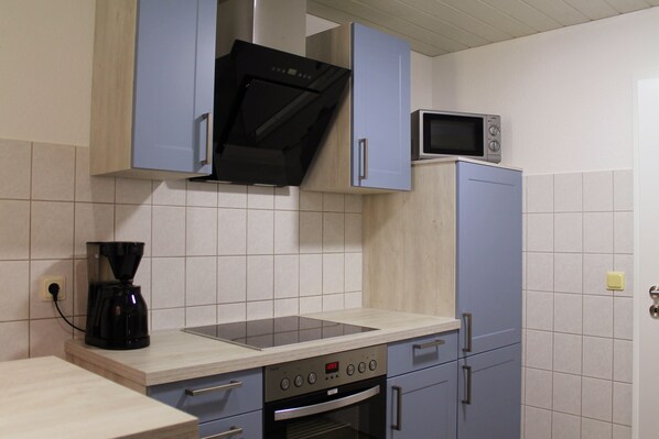 A kitchen with a microwave, stove, and coffee maker.