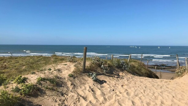 A sandy beach with a wooden fence and sparse vegetation. - Home on the front line! (Bretignolles-sur-Mer)