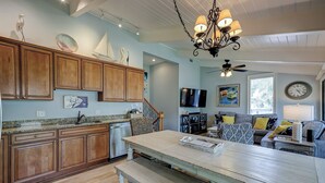 A spacious kitchen with wooden cabinets, a large island, and a dining area with a bench.