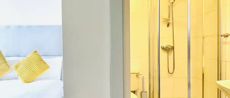A hotel room with a bed, a shower, and a toilet.