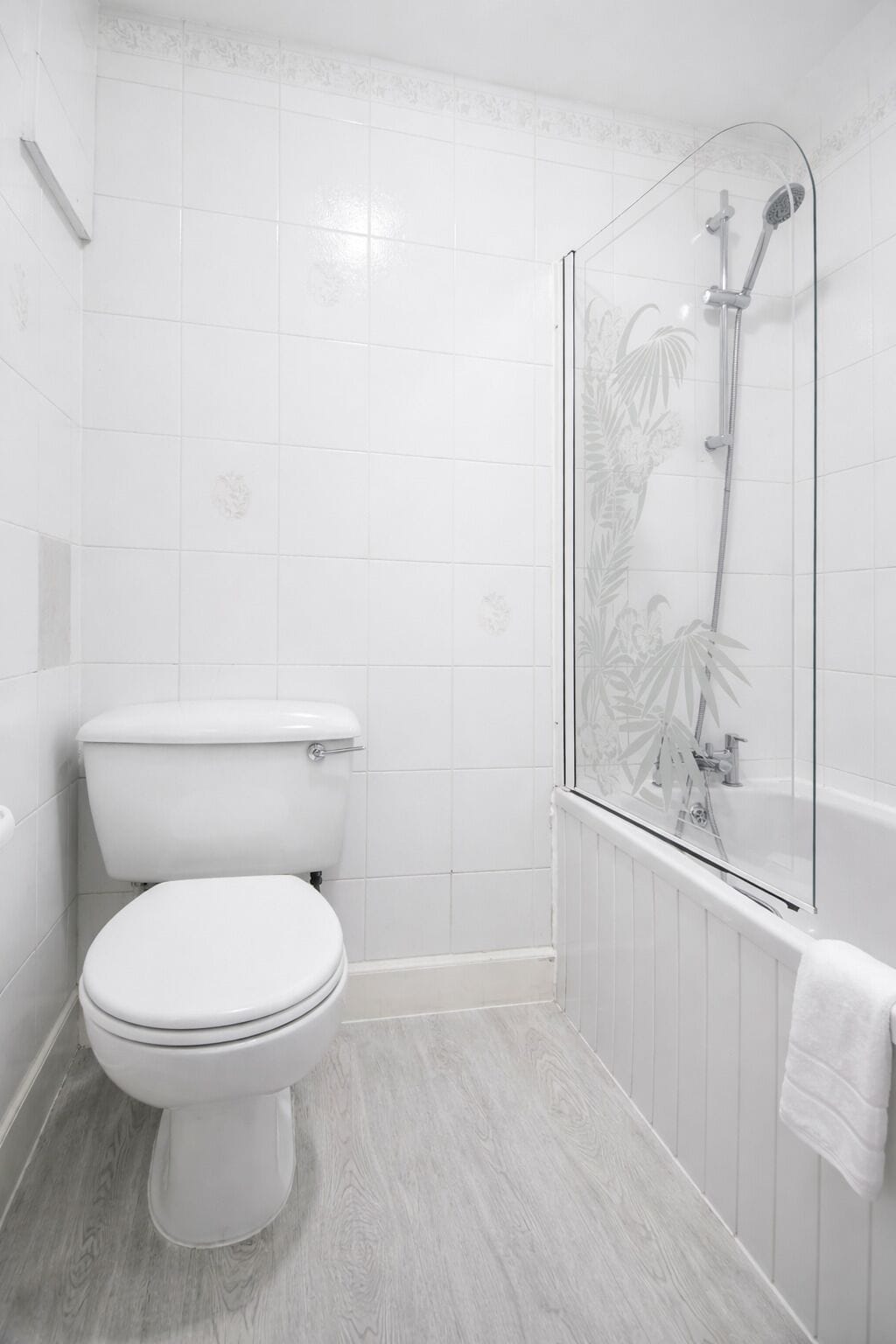 A bathroom with a toilet, a shower with a glass door, and a bathtub.