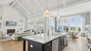 A modern kitchen with a large island, stainless steel appliances, and a view of the outdoors. - Luxe,Pet-Friendly,Lake Living@Cinnamon Shore! Game Rm, Amenities&Close Pools! (Port Aransas)