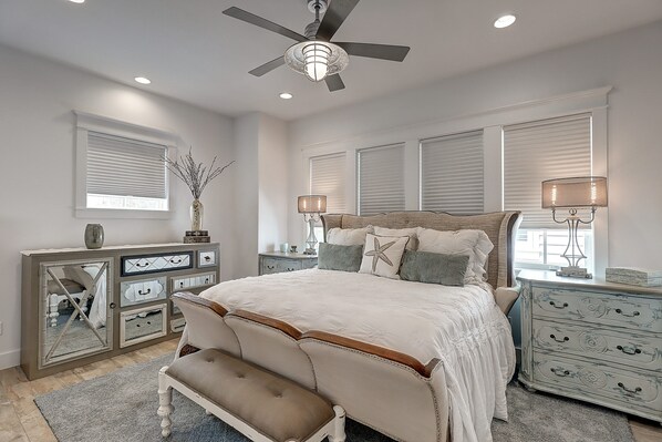 A bedroom with a bed, a bench, a dresser, and a nightstand.
