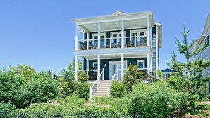 A two-story house with a balcony on the upper floor, surrounded by greenery. - Simply The Best - At Angler's Nest! (Lewes)