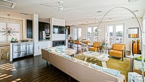 A spacious living area with a large sofa, a dining table, and a kitchen in the background. - Simply The Best - At Angler's Nest! (Lewes)