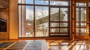 A room with large windows, a stone fireplace, and wooden flooring. - Perfect view of Super Bee, ski-in/out, wonderful sunlight, free WiFi, parking (Copper Mountain)