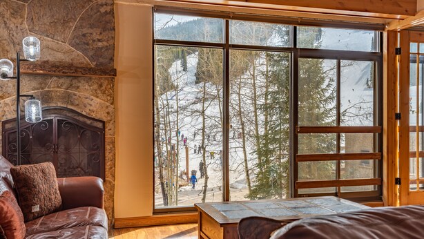 A cozy room with a large window, a fireplace, and a leather sofa. - Perfect view of Super Bee, ski-in/out, wonderful sunlight, free WiFi, parking (Copper Mountain)