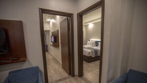 Een hotelkamer met een bed, een televisie en een spiegel die de kamer weerspiegelt.
