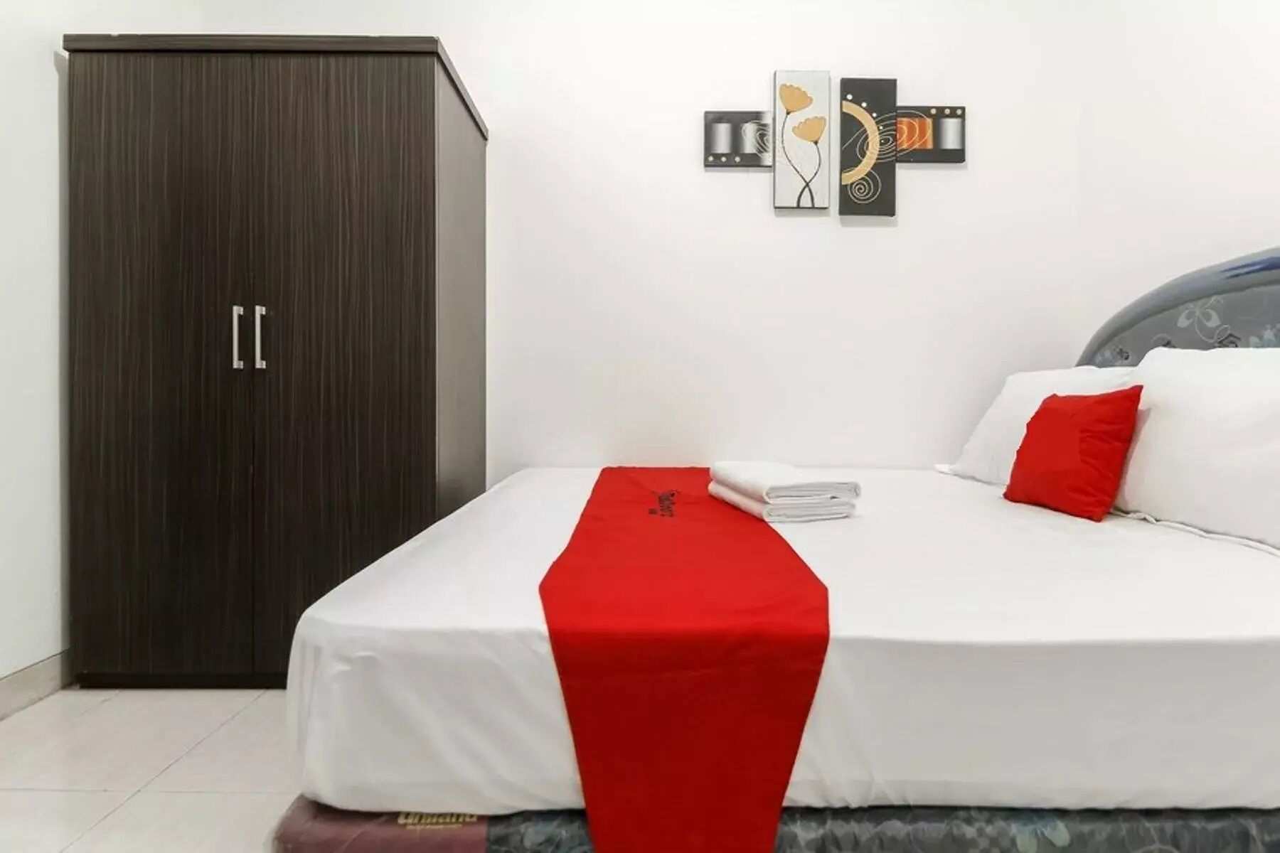 Une chambre d’hôtel avec un lit, une armoire et une œuvre d’art accrochée au mur.