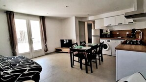 A compact living space with a dining area, a washing machine, and a kitchenette. - T3 with pool 2mn from the beach (Pietracorbara)