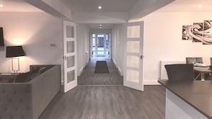 Una cocina moderna con comedor, un pasillo que lleva a un balcón y vistas al exterior.