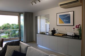 Una cocina moderna con un ventanal grande, un área de comedor con sofá y una obra de arte enmarcada en la pared.