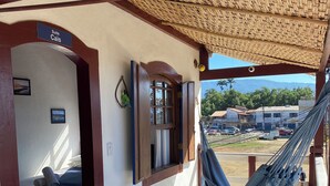 Una habitación con cama, una hamaca y vistas al exterior.