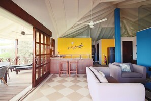 Relax in this inviting living area with a checkered floor, modern kitchen, and cozy seating area.
