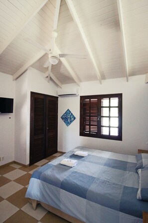 Relax in this inviting room with a high ceiling, exposed beams, and a comfortable bed.
