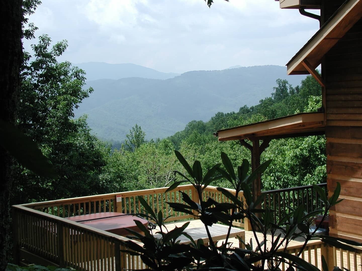 Une terrasse en bois offrant une vue sur une chaîne de montagnes.