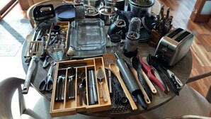 A table with various kitchen utensils and cookware, including pots, pans, and a toaster. - O'Connors Retreat - Blowing Rock, Hot tub Secluded acreage, fabulous views (Lenoir)