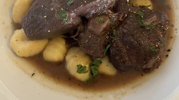 Un tazón de estofado de carne con papas y hierbas.