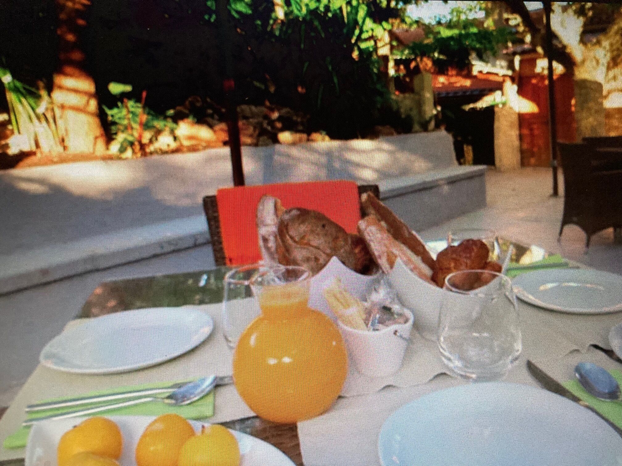 Una tavola apparecchiata per la colazione, con piatti, bicchieri e un cestino di pane.