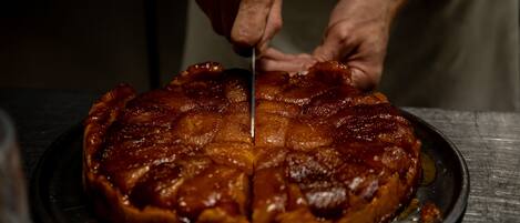 Una persona cortando un pastel glaseado sobre un plato de metal.
