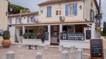 A restaurant with a signboard displaying its name and contact details.