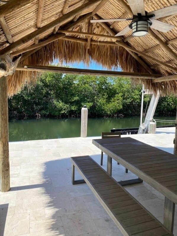 Un espace extérieur abrité, doté d’une terrasse en bois, d’une table et d’un banc.