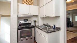 A kitchen with white cabinets, a stainless steel stove, and a granite countertop. - Downtown Fargo Gem: Full Home for Large Groups (Fargo)