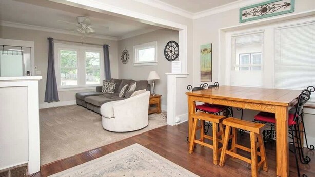 A living room with a wooden dining table, two chairs, a sofa, and a fireplace. - Downtown Fargo Gem: Full Home for Large Groups (Fargo)