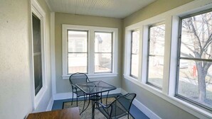 A sunlit room with a dining table and chairs, large windows, and a view of the outside. - Downtown Fargo Gem: Full Home for Large Groups (Fargo)