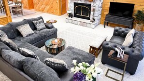 A cozy living room with a fireplace, a sofa set, a coffee table, and a television. - The Lakefront Lodge near CHQ Institution (Mayville)