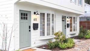 A white two-story house with the number 611 on the front door, a mailbox, and a small garden with plants and a stone pathway. - Closest Stay to Downtown Mt Dora - Renovated - Walk Everywhere (Mount Dora)