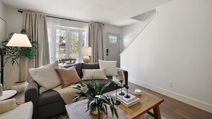 A modern living room with a sofa, coffee table, and a lamp. - Closest Stay to Downtown Mt Dora - Renovated - Walk Everywhere (Mount Dora)