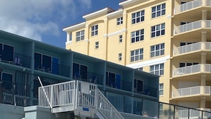 Un edificio de varios pisos con balcones y una escalera que conduce a un nivel superior.