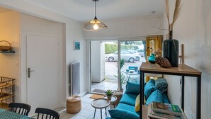 Ein modernes Wohnzimmer mit einer Couch, einem Esstisch und einer Pendelleuchte.