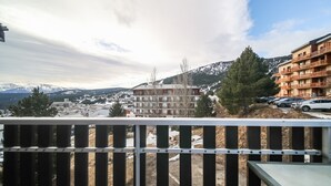Ein Balkon mit Blick auf eine Stadt, Berge und ein Gebäude mit Balkonen.