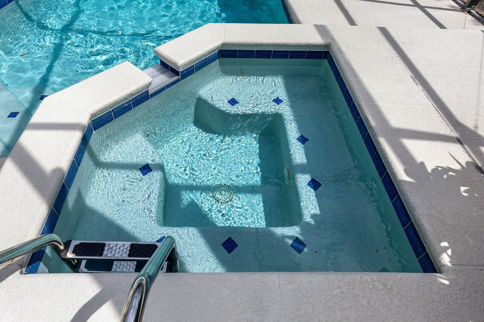 Una piscina con borde de azulejos e hidromasaje integrado.