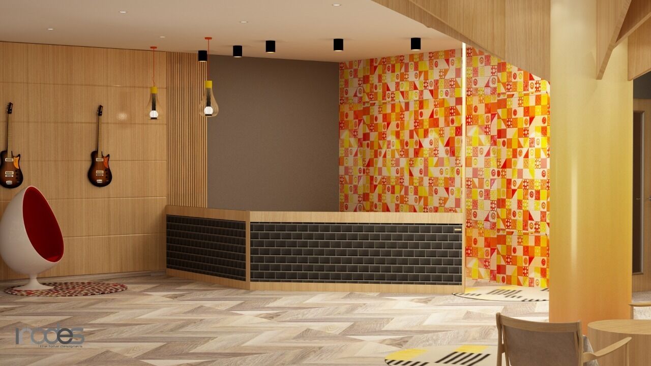 Un espace d’accueil moderne avec un comptoir de réception en bois, un mur aux motifs géométriques colorés et un fauteuil rouge et blanc original.