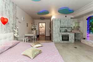 Une chambre moderne dotée d’un grand lit, d’un coin repas et d’une cuisine.