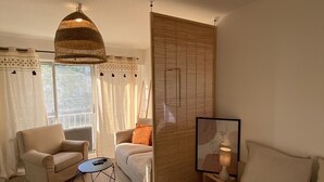 A bedroom with a bed, a sofa, a coffee table, and a hanging lamp. - New Studio - City Center Mulhouse - Near Train station (Mulhouse)