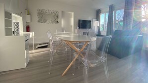 A modern kitchen with a dining area, a ceiling fan, and a TV. - #Casafouilloy Apartment with large terrace (Fouilloy)