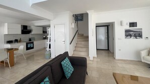 Un apartamento moderno con cocina, sala de estar y escalera.