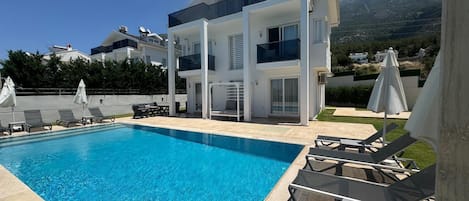 A heated pool, sun loungers