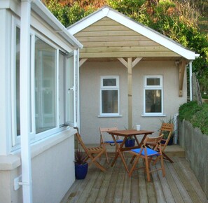 Relax in a serene outdoor space with a wooden deck, table, and comfortable seating for four.
