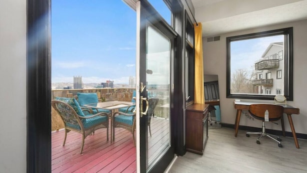 A balcony with wicker furniture and a view of the city skyline. - ★ HostWise Stays ★ Skyline Splendor w/ Private Balconies & Game Room (Pittsburgh)