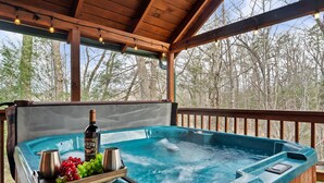 Ein Whirlpool mit Holzterrasse und einer darüber liegenden Holzpergola.
